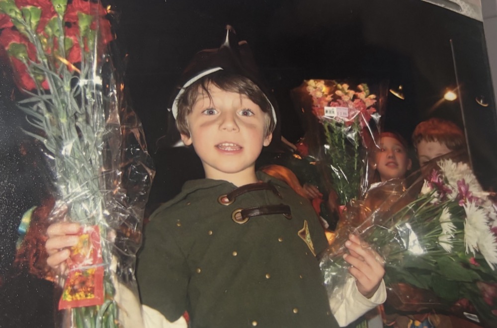 ADDANTE as a kid in a costume holding flowers