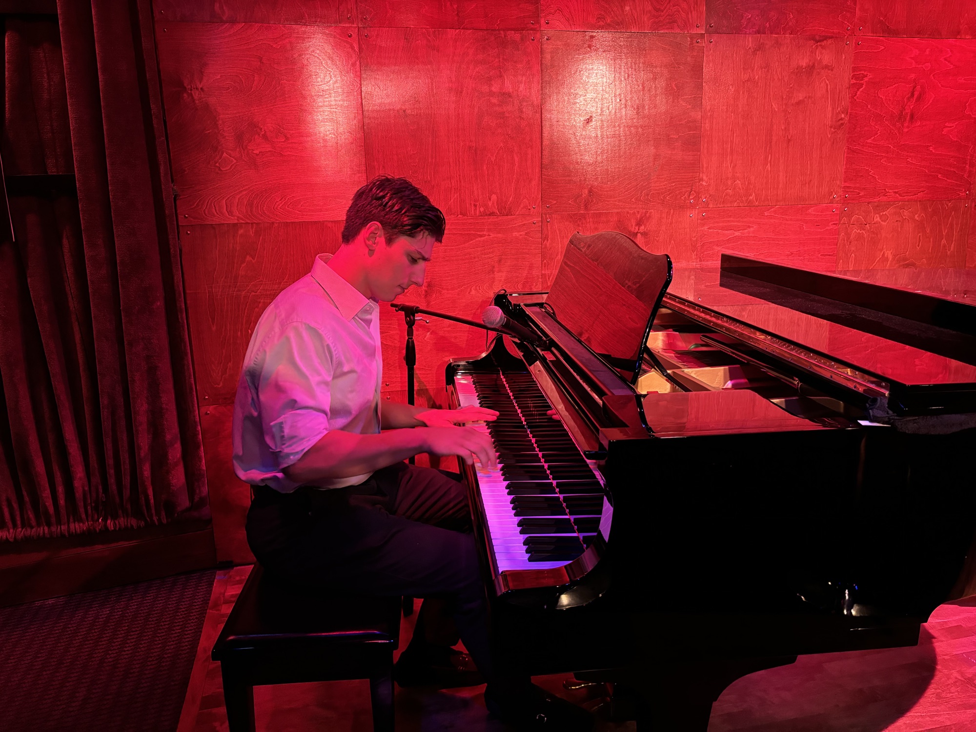 ADDANTE performing at a grand piano under red stage lighting